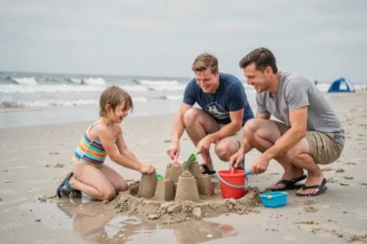 Famille construisant un château de sable sur la plage du Touquet, parents et enfants souriants sous un ciel nuageux typique de la côte d'Opale