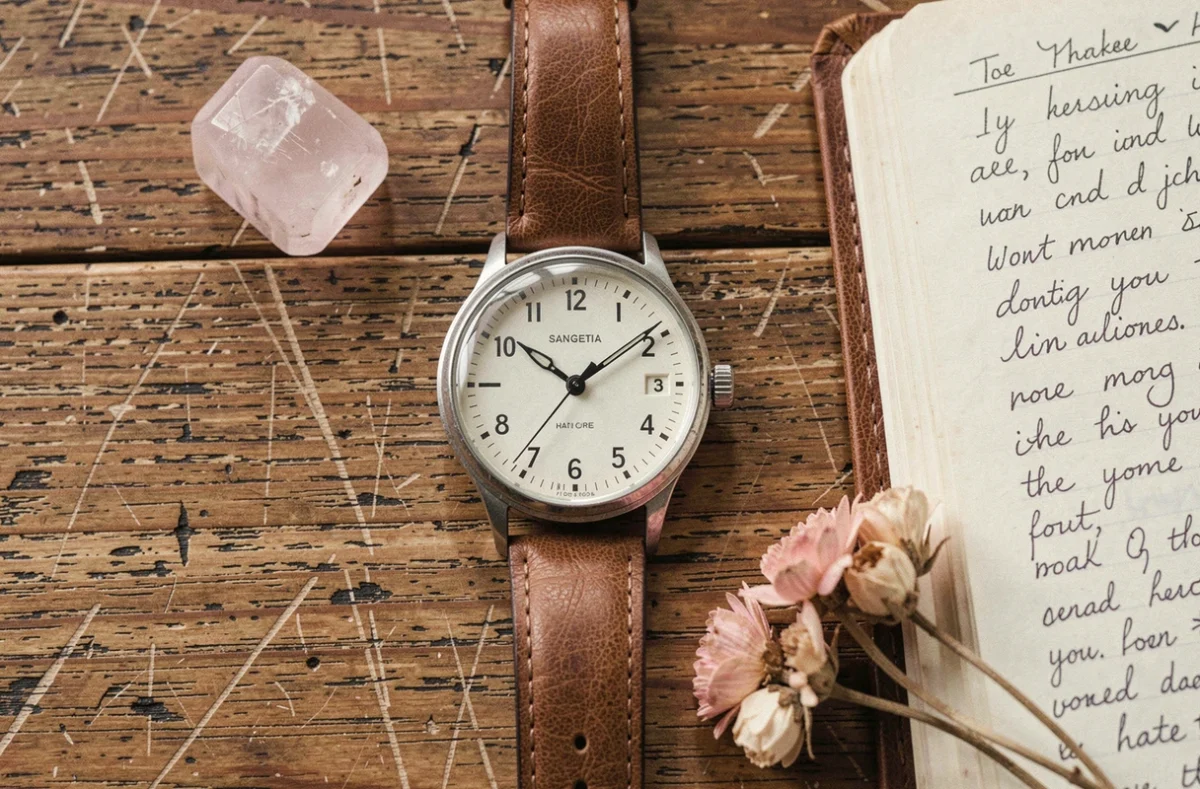 Flatlay détaillé d'une montre ancienne indiquant 1h11 entourée de cristaux et d'un journal intime, illustrant la symbolique spirituelle de l'heure miroir et de la flamme jumelle